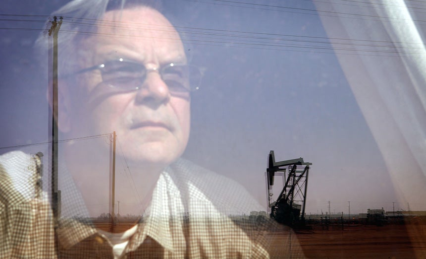 Walt Desatoff looks out window at oil field across the street