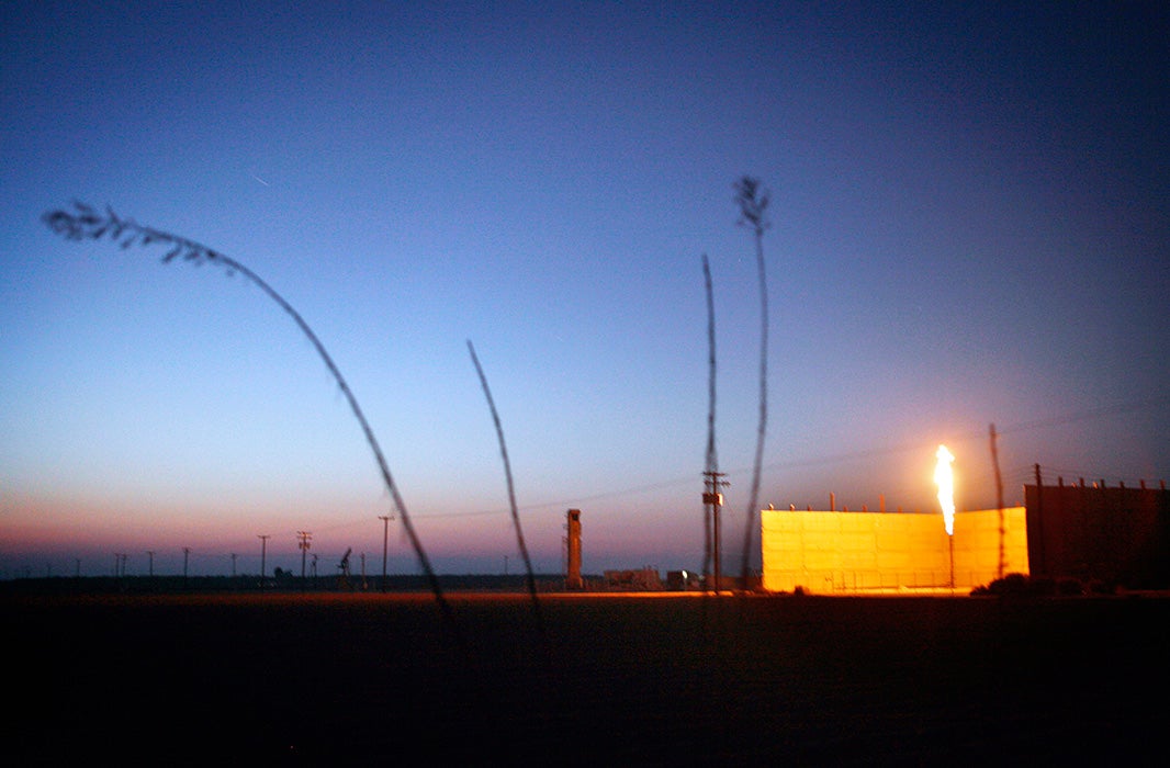 As the sun sets on another California day, a flare burns in an oil field in Shafter, CA.