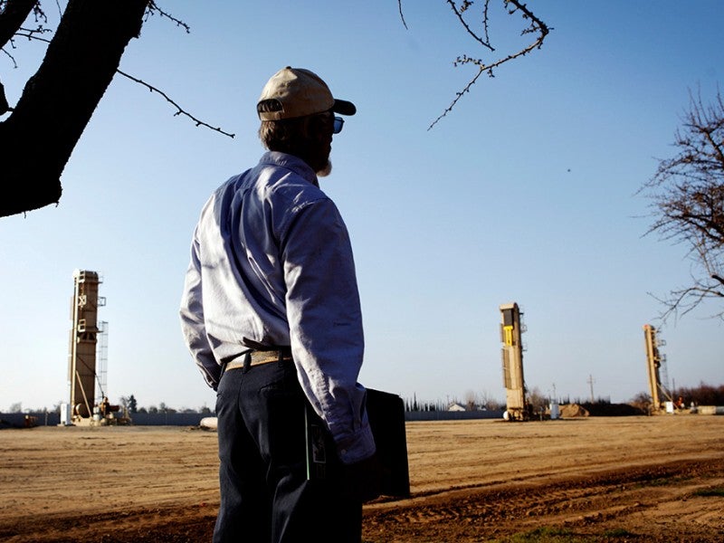 An almond farmer watches oil wells that have sprouted next to almond orchards near Bakersfield, CA. Many worry that the new techniques being used to go after the oil, such as horizontal drilling and hydraulic fracturing, could potentially damage groundwater in agricultural areas.
(Chris Jordan-Bloch / Earthjustice)