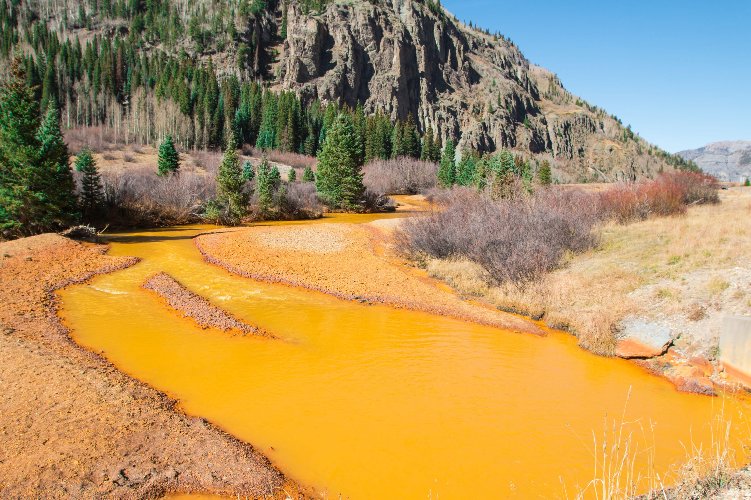 Toxic waste stains water yellow-orange near abandoned mines in Colorado.