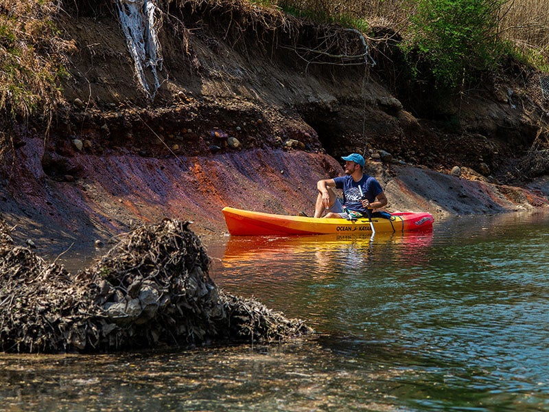 Andrew Rehn of Prairie Rivers Network looks at toxic coal ash waste seepage on the shore of the Middle Fork of the Vermilion River in Illinois.