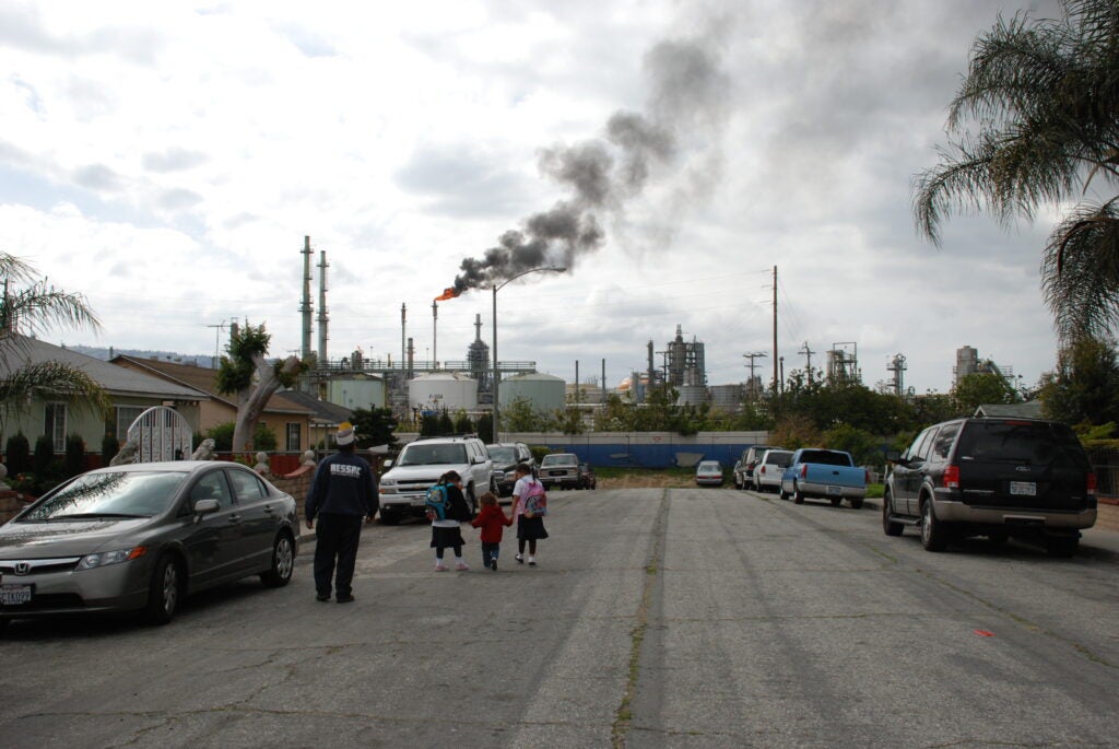 Children in the danger zone in Wilmington, CA, walk near a Conoco Phillips oil refinery. (Photo provided by Jesse Marquez)
