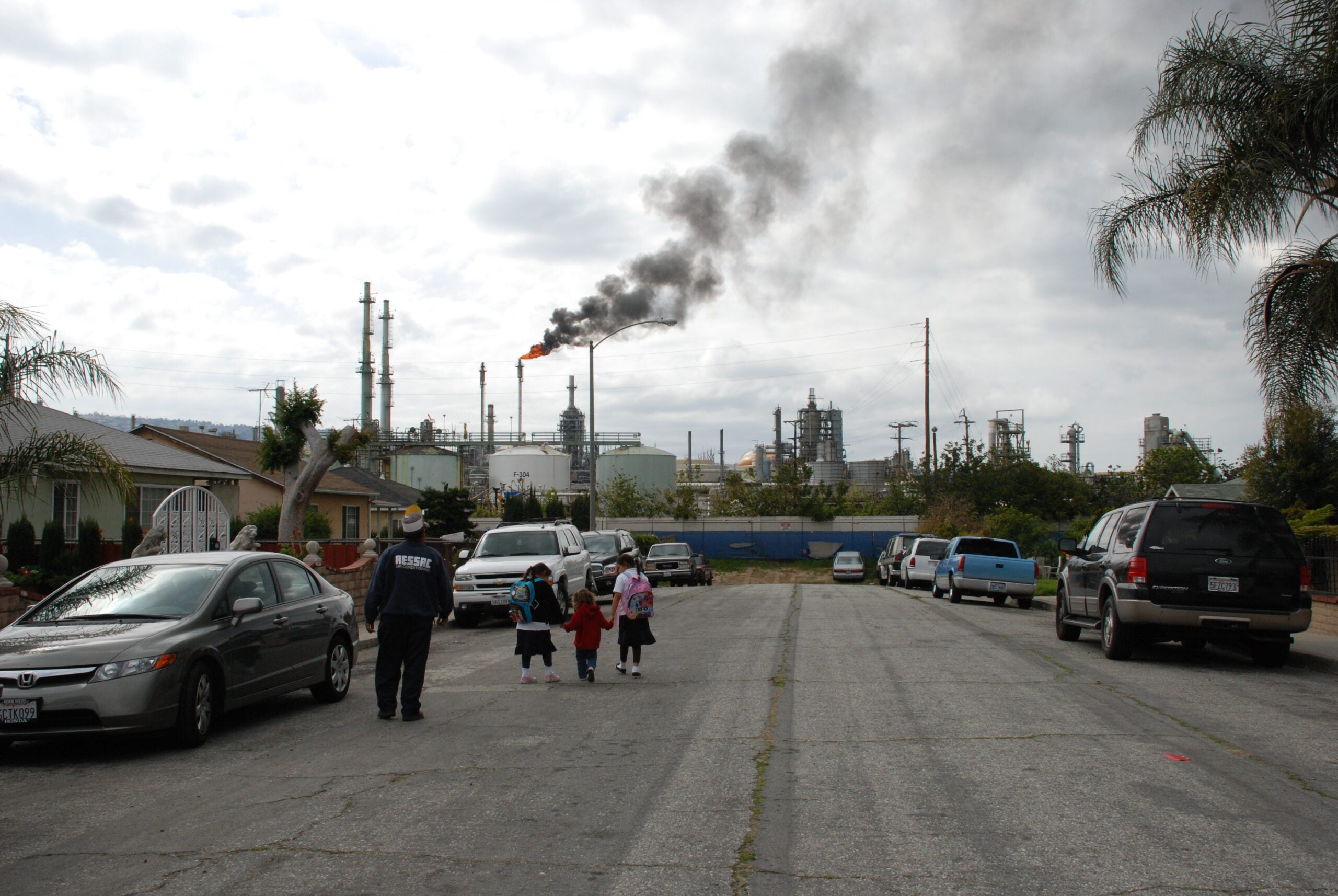 Children in the danger zone in Wilmington, CA, walk near a Conoco Phillips oil refinery.
(Photo provided by Jesse Marquez)