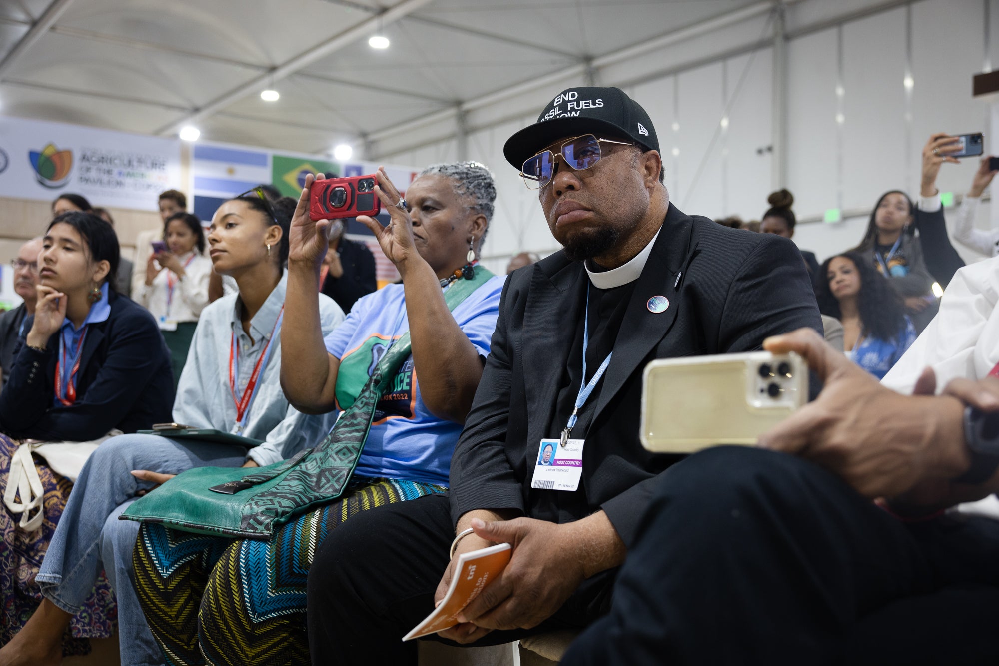Rev. Lennox Yearwood, Jr., President of the Hip Hop Caucus, foreground, is among the audience as former U.S. Vice President Al Gore — founder of the Climate Reality Project — delivers an address at the Climate Justice Pavilion.