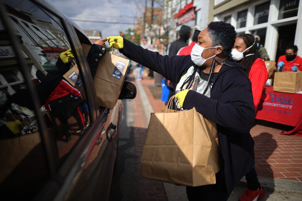 Voluntarios de una organización sin fines de lucro en Washington, D.C., distribuyen comida caliente gratis durante la pandemia COVID-19.