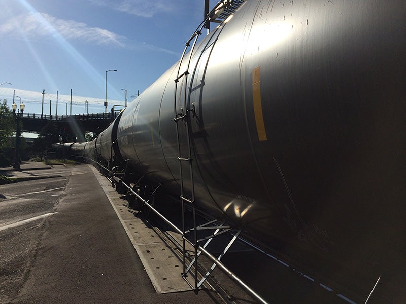 A crude oil train travels through Portland, OR. Global Partners LP has been moving highly volatile Bakken crude oil on trains (prone to explosion and fire) through Portland and other towns to the Clatskanie terminal, with no federal permit controls.
(Photo courtesy of Sam Beebe)