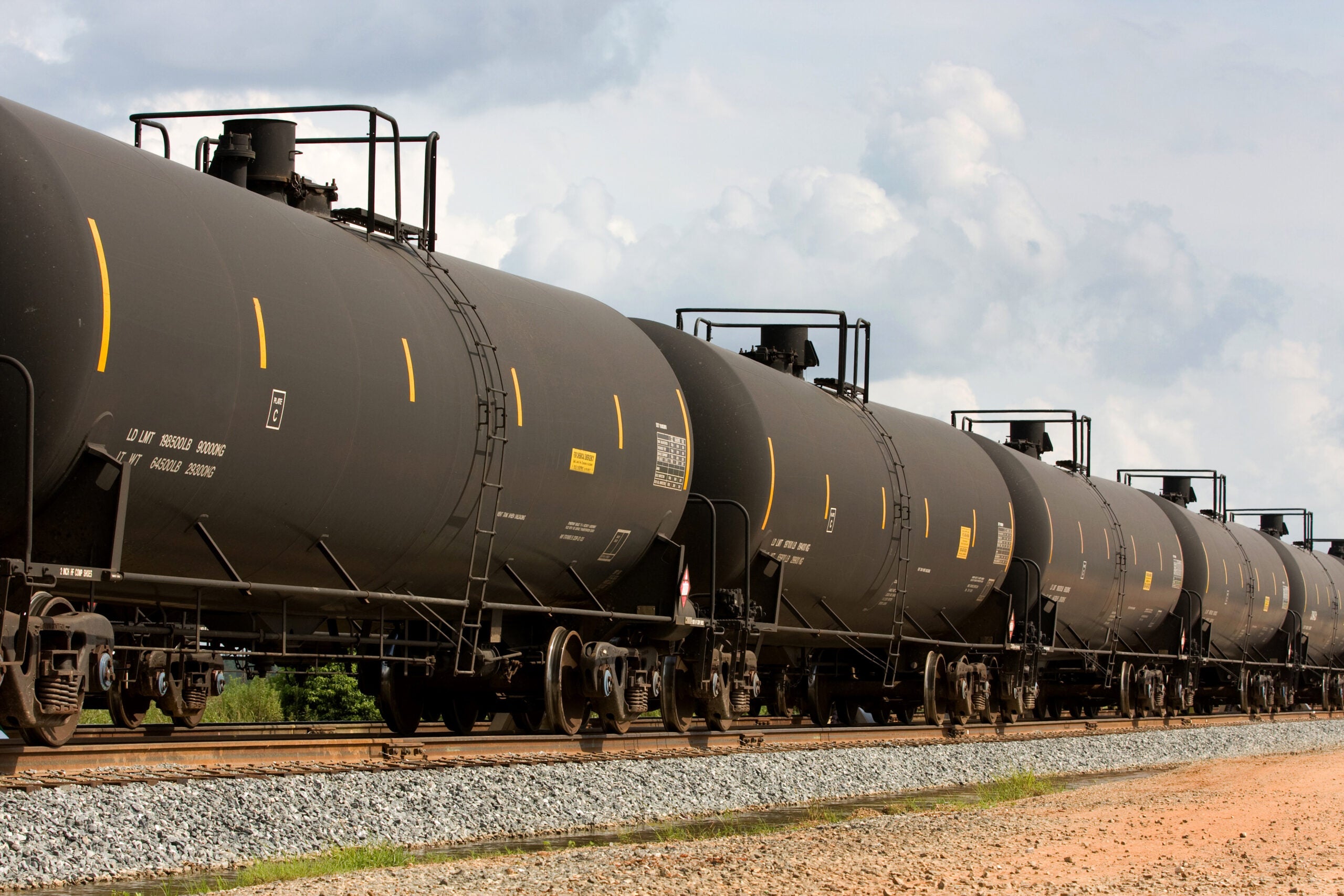 Railroad train of tanker cars transporting crude oil on the tracks.