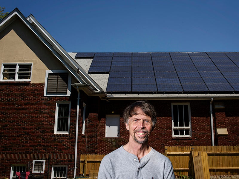 David Brosch stands in front of a 22 kilowatt solar electric array atop the roof of the University Park Church of the Brethren in Maryland.