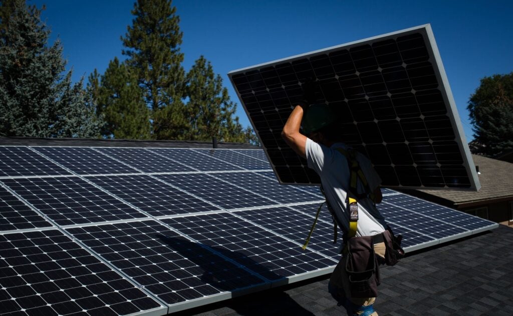 Workers for EcoDepot Inc. install solar panels on a roof in Spokane, Washington.