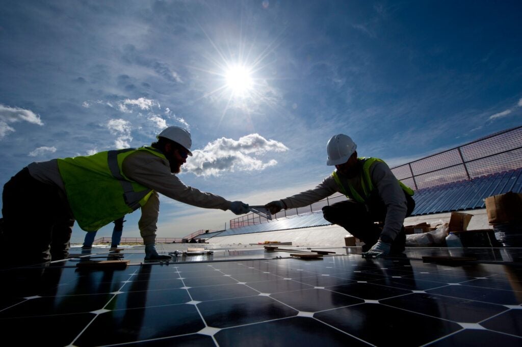 Workers install solar panels on a parking structure at the National Renewable Energy Laboratory in Golden, Colorado.
(Photo by Dennis Schroeder / NREL)