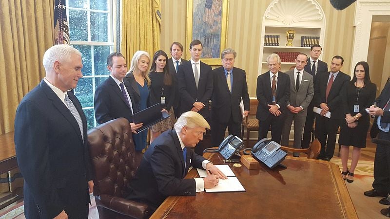 President Donald Trump signs Executive Orders in the Oval Office.