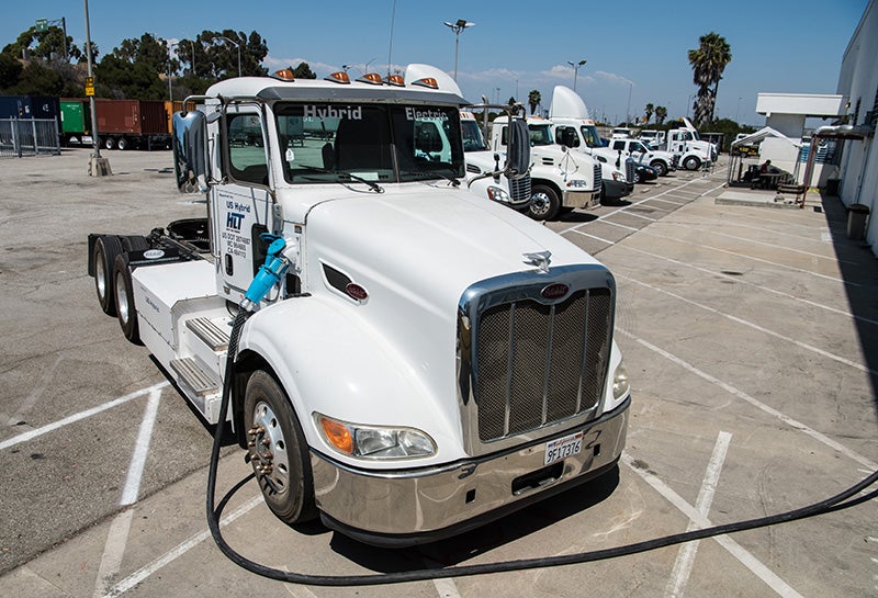 An electric hybrid heavy duty truck, used to move freight at the Port of Long Beach in California, is plugged in to charge. (Dennis Schroeder / NREL)
