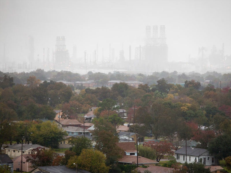 An oil refinery looms over Port Arthur, TX. People of color are nearly twice as likely as white Americans to live within a fenceline zone of an industrial facility.