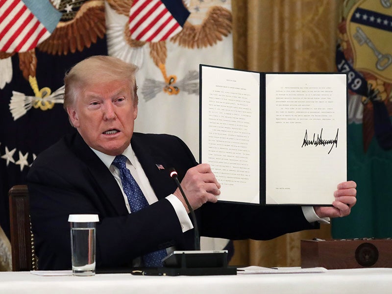 President Donald Trump displays the executive order signed on May 19, 2020, requiring agencies to search for public protections to suspend in the middle of the global respiratory pandemic.