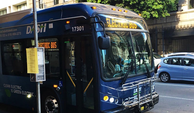 An electric public bus in Los Angeles stops at a bus stop.