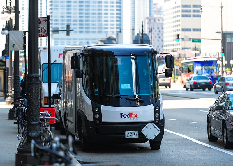 An electric FedEx delivery truck makes deliveries in Illinois.