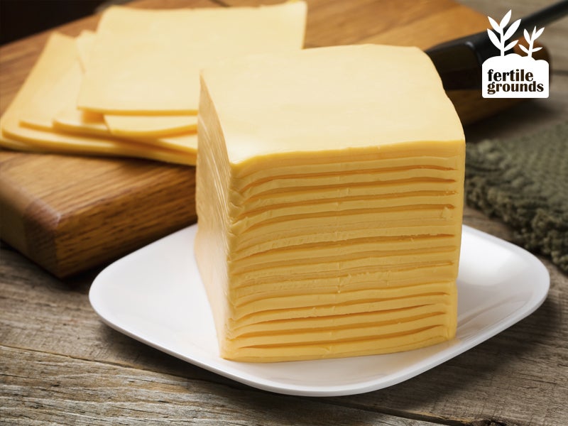 A tall stack of American sliced cheese on a plate.