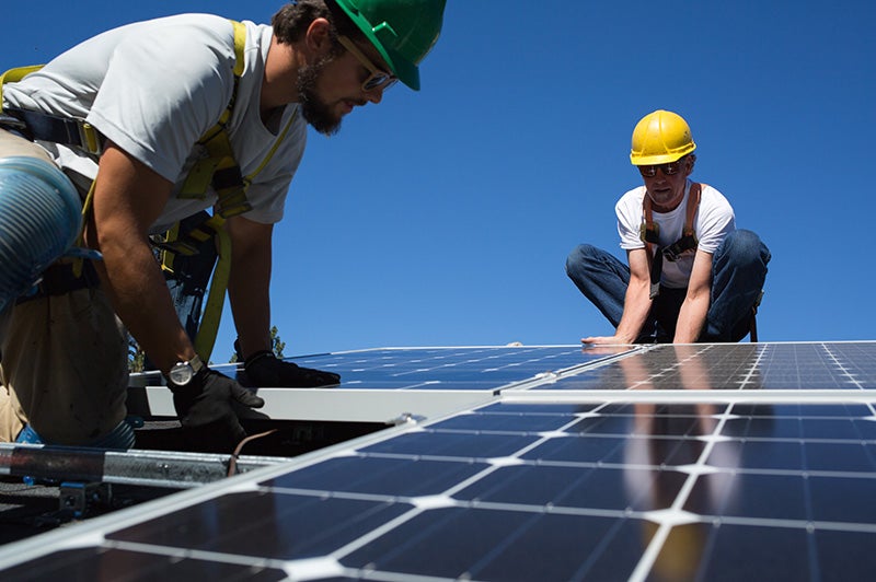 Technicians install solar panels on a home in Spokane, Washington.