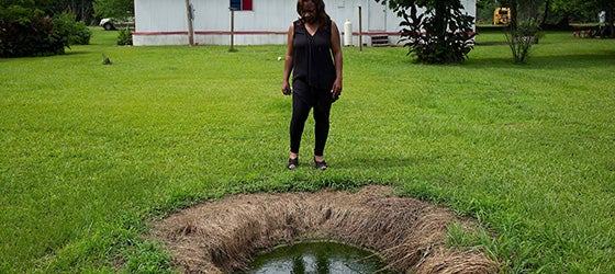 Catherine Coleman Flowers stands over a pool of raw sewage outside a home in White Hall, Alabama. For over a decade Flowers has worked as an advocate in the Black Belt, where improper sewage treatment has put the population at risk of infectious diseases. (Bob Miller / Redux)