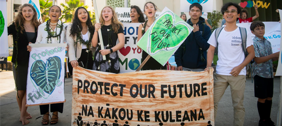 Youth plaintiffs and supporters hold up signs after the Navahine vs the Hawaiʻi Department of Transportation court hearing in Honolulu, Hawaiʻi on January 26th 2023. (Elyse Butler for Earthjustice)