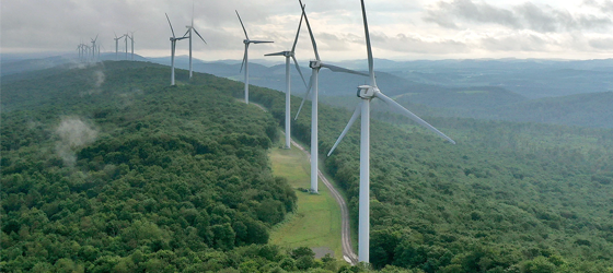 In this aerial view, turbines stand in a row along the top of Backbone Mountain on August 22, 2022 in Oakland, Maryland. The 70-megawatt wind farm runs along eight miles of the mountain ridge and consists of 28 Clipper 2.5 MW Liberty Turbines, each one 415-feet tall. (Chip Somodevilla / Getty Images)