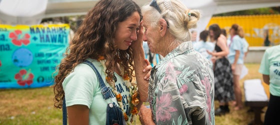 Youth plaintiff Kalā W. shares an emotional moment with an elder on Jun. 24, 2024, during the celebration of the historic settlement in Navahine v. Hawaiʻi Department of Transportation. (Elyse Butler for Earthjustice)