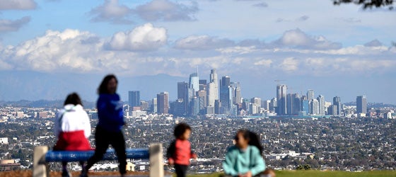 People enjoy a sunny afternoon in a Los Angeles park with a view of the downtown skyline. (Chris Delmas / AFP via Getty Images)