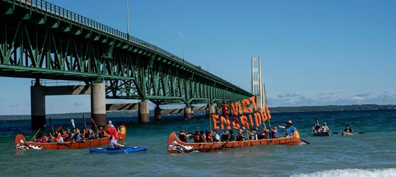 Protestors paddle next to the Mackinac Bridge at the Pipe Out Paddle Up Flotilla Against the Line 5 pipeline in Mackinaw City, Michigan. (Sarah Rice for Earthjustice)