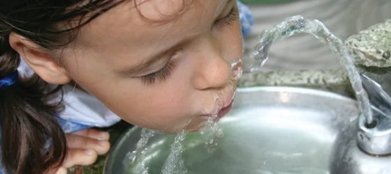 A child drinks from a water fountain. (iStockphoto)
