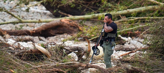 A sheriff's deputy pauses while combing through the banks of the Guadalupe River after a flash flood swept through the area in July 2025. (Julio Cortez / AP)