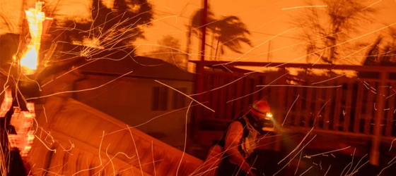 Strong winds blow embers around firefighters battling to save homes in Pasadena, Calif., from the Eaton Fire on Jan. 7, 2025. (David McNew / Getty Images)