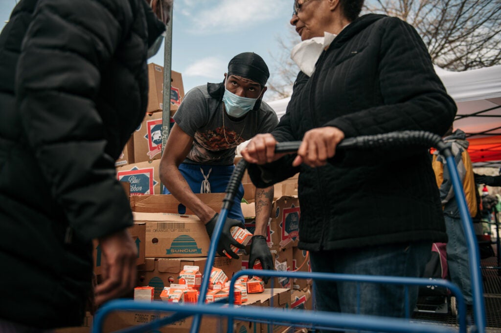 A worker distributes orange juice in Brooklyn on April 14, 2020. The coronavirus crisis is increasing food insecurity across the country.
(Scott Heins / Getty Images)