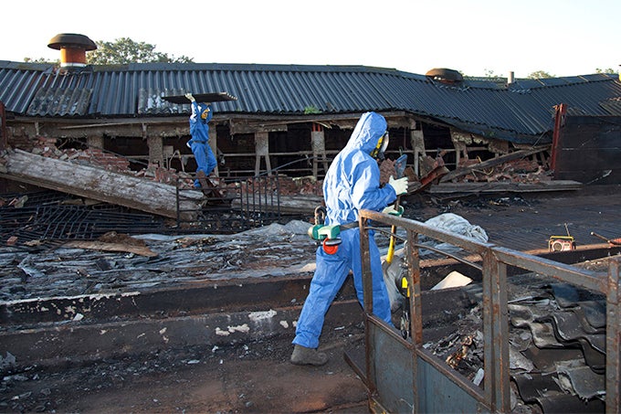 Workers wear protective gear as they remove asbestos, one of the substances regulated under the Toxic Substances Control Act.
(BartCo / Getty Images)