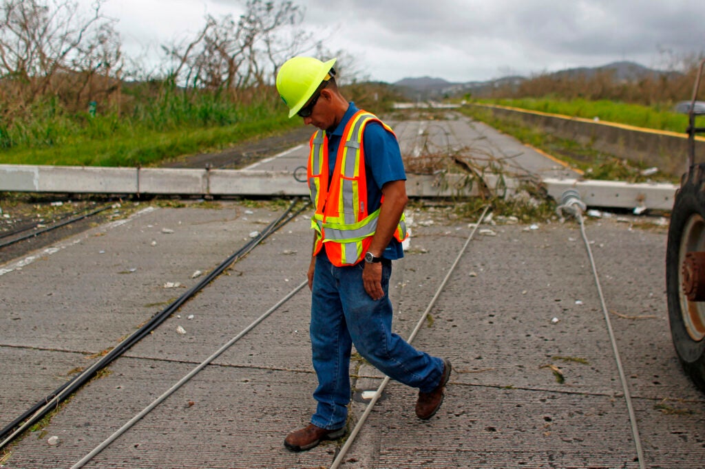 A Puerto Rico Power Authority worker walks between downed power lines in the aftermath of Hurricane Maria in Luquillo, Puerto Rico, Thursday, September 21, 2017.
(Ricardo Arduengo / AFP via Getty Images)