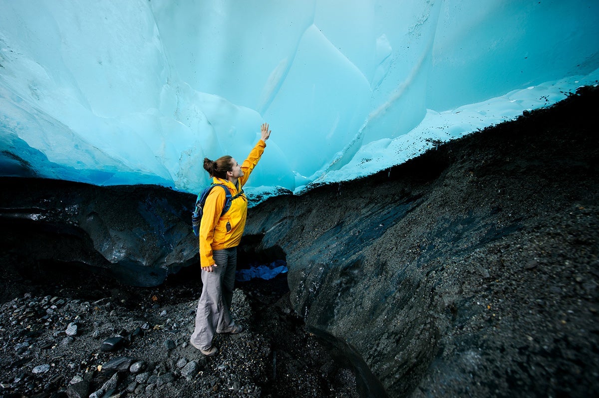 A hiker touches the Mendenhall Glacier in Tongass National Forest.