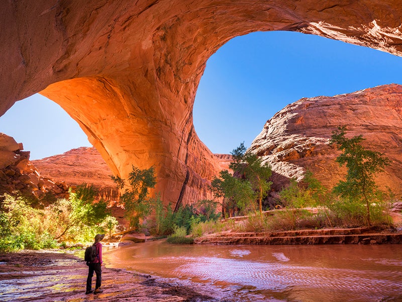 A hiker at Jacob Hamblin Arch in Coyote Gulch, Grand Staircase-Escalante National Monument, Utah.