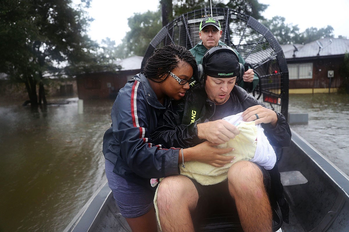 A mother and her 3-week-old baby are ferried from their home amidst the floodwaters of Hurricane Harvey in 2017.
