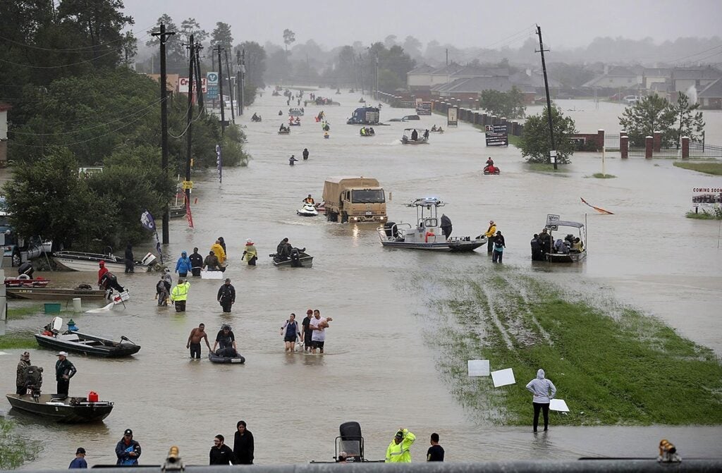 Houston residents escape flooded homes and businesses, in the aftermath of Hurricane Harvey in 2017. (Joe Raedle / Getty Images)