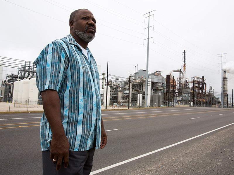 Hilton Kelley stands in front of the Valero oil refinery in Port Arthur, TX, in late November 2013.