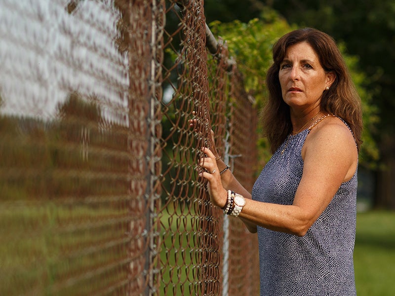 Hope Grosse stands next to the Naval Air Warefare Center in Warminster, Pennsylvania, where PFAS-laden firefighting foam poisoned local streams.