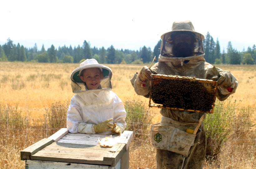 Eric McEwen and his daughter Fern Waters McEwen working on their apiary.