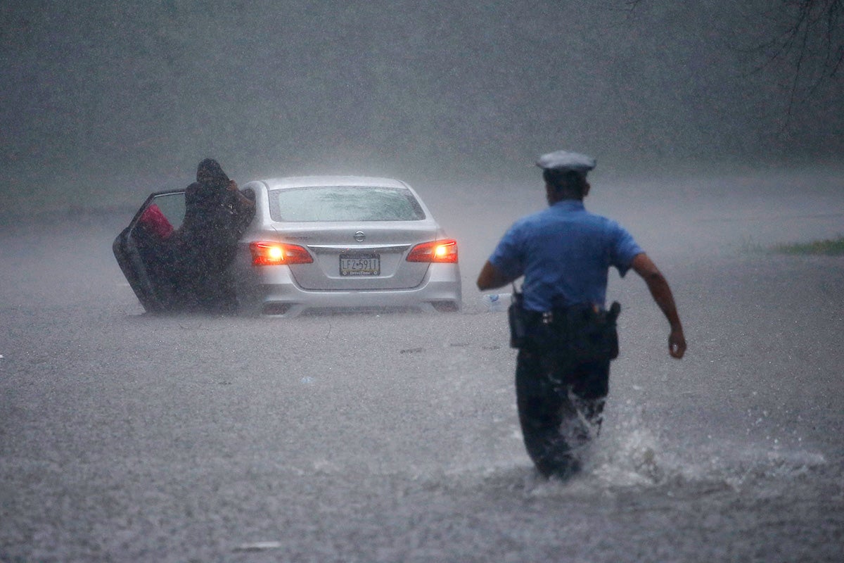 A Philadelphia police officer rushes to help a stranded motorist during Tropical Storm Isaias, Aug. 4, 2020.