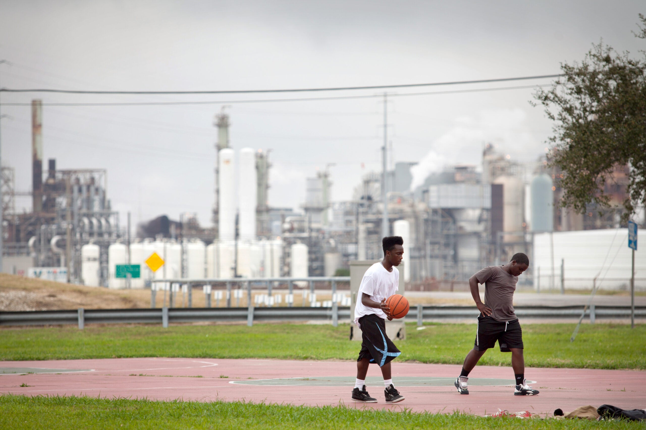 Teenagers play basketball in the Carver Terrace housing project in 2013 in Port Arthur, Tex.