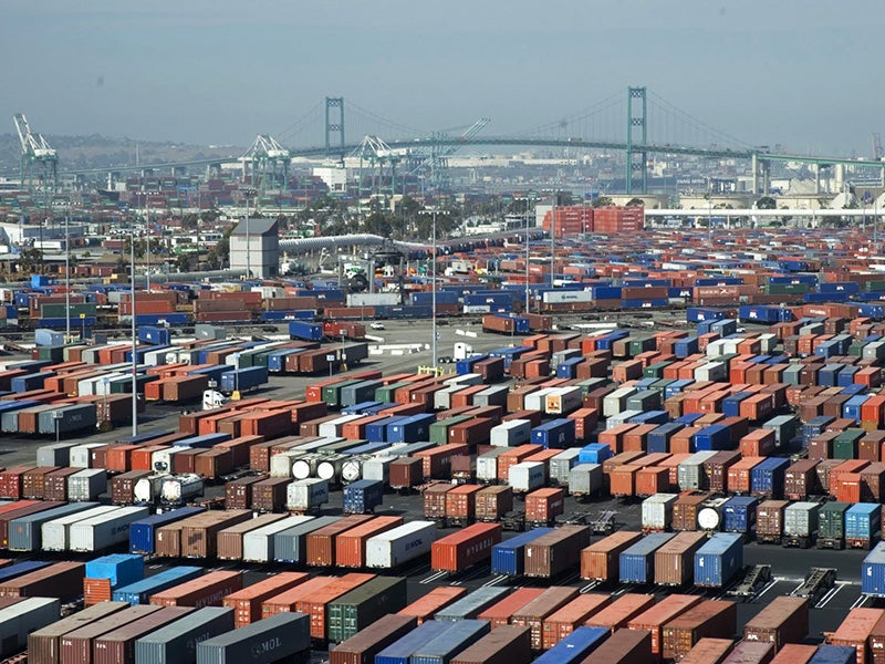 A rail line runs past shipping containers at the Port of Long Beach.