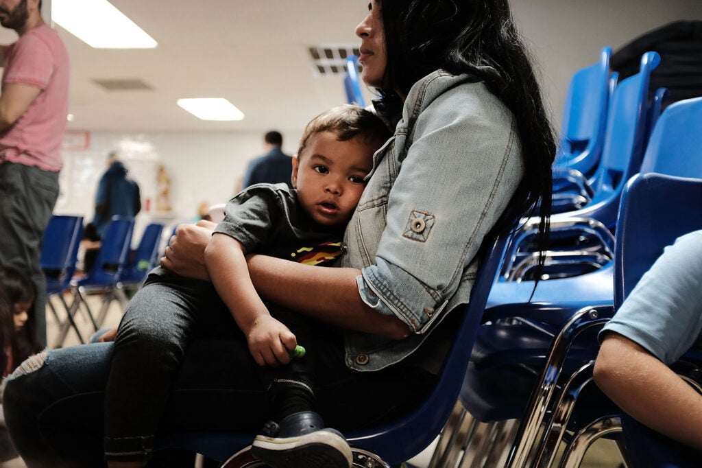 A woman who identified herself as Jennifer sits with her son Jaydan at the Catholic Charities Humanitarian Respite Center after crossing the U.S.-Mexico border in McAllen, Tex., in 2018. (Spencer Platt / Getty Images)