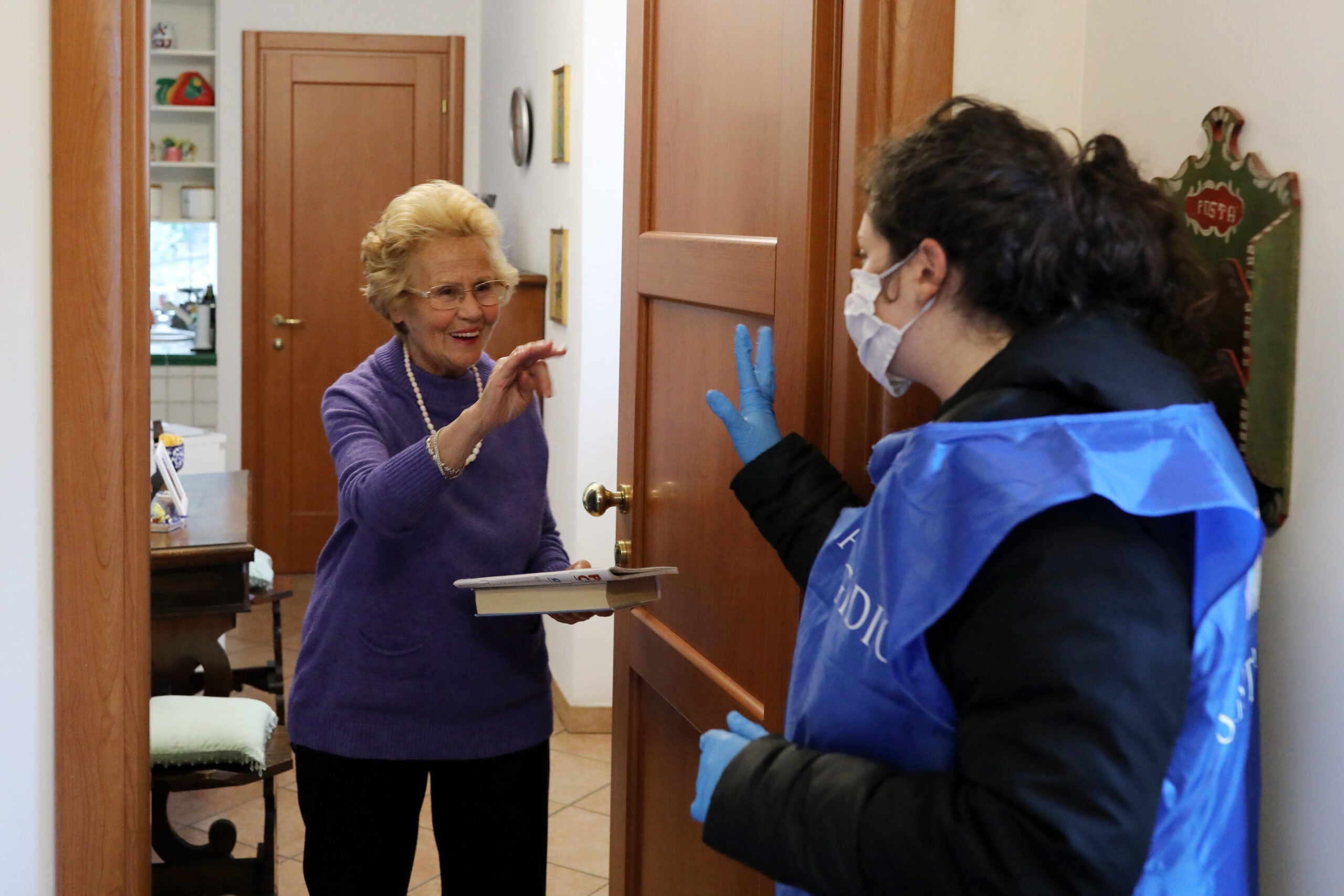 A volunteer speaks to a woman she&#039;s providing with home care in Rome during Italy&#039;s COVID-19 lockdown.