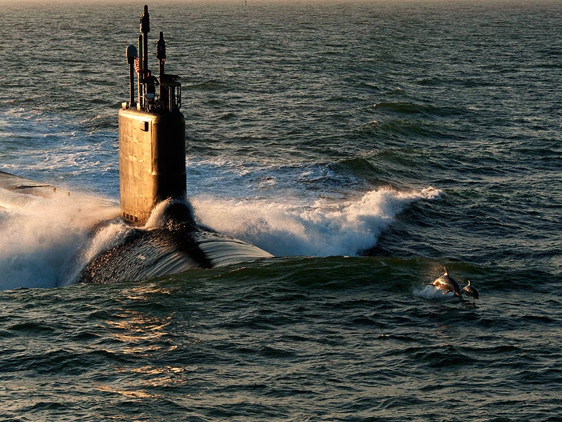 Dolphins swim in advance of Virginia-class attack submarine PCU Minnesota.
(U.S. Navy photo courtesy of Huntington Ingalls Industries)