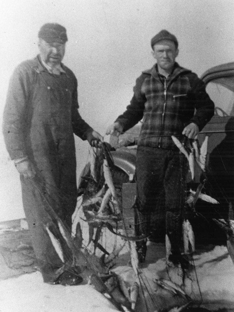Black and white image of Bill Parish and Woodrow Willcox lifting nets off Iroquois Island, in the Bay Mills township.