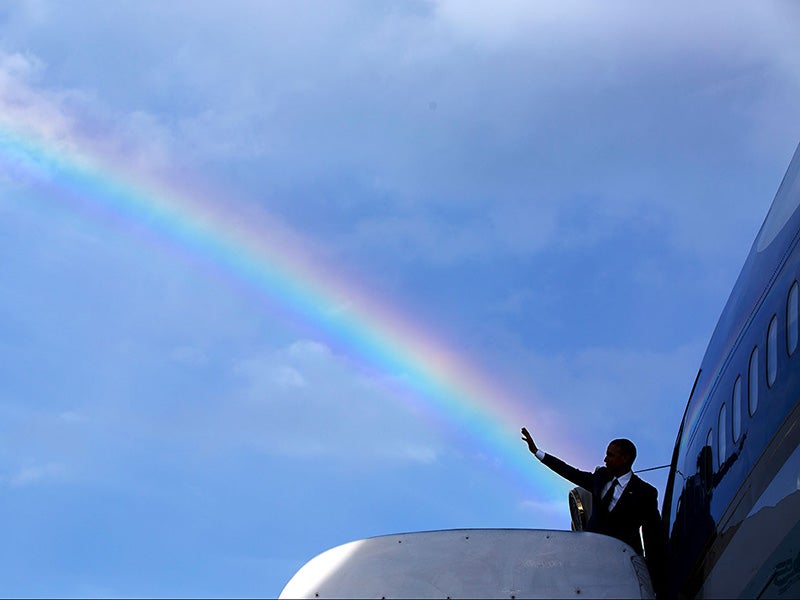 President Barack Obama&#039;s wave aligns with a rainbow as he boards Air Force One, April 9, 2015.