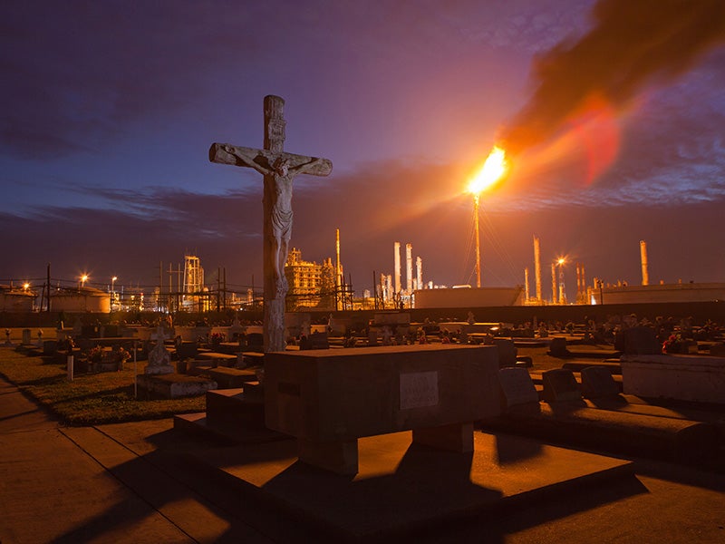 In Louisiana's 'Cancer Alley, a cemetery stands in stark contrast to the chemical plants that surround it.